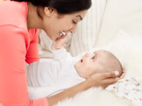 mother pumping breastmilk with Medela Freestyle breastpump while reading a magazine